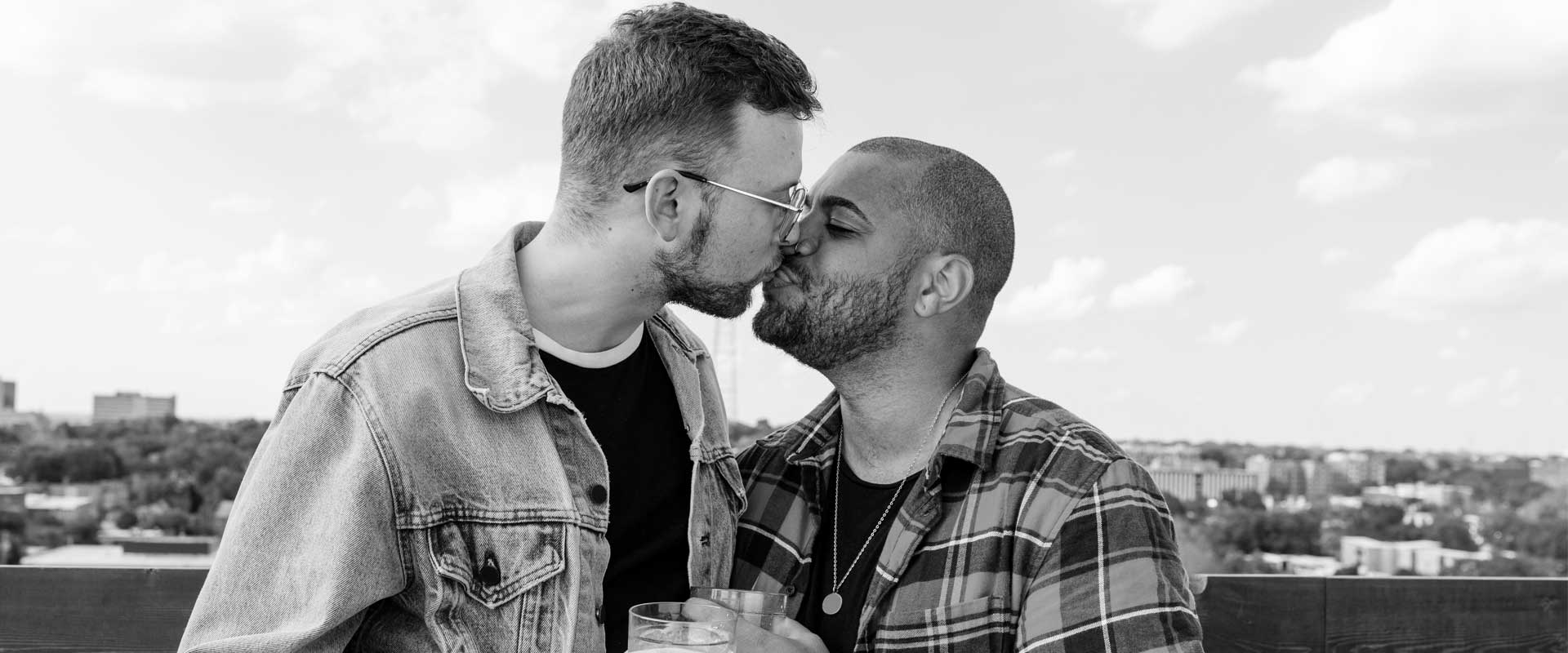 Two gay boys kissing each other in front of a view of a landscape decriminalize homosexuality